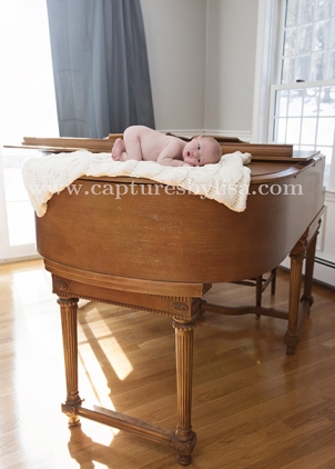 Bolton newborn baby on grand piano